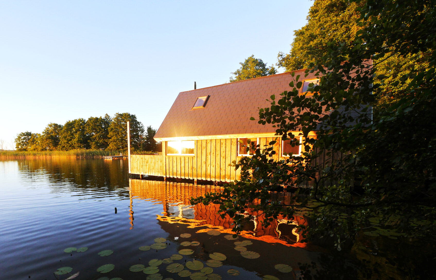 the sun reflects off a home on a lake