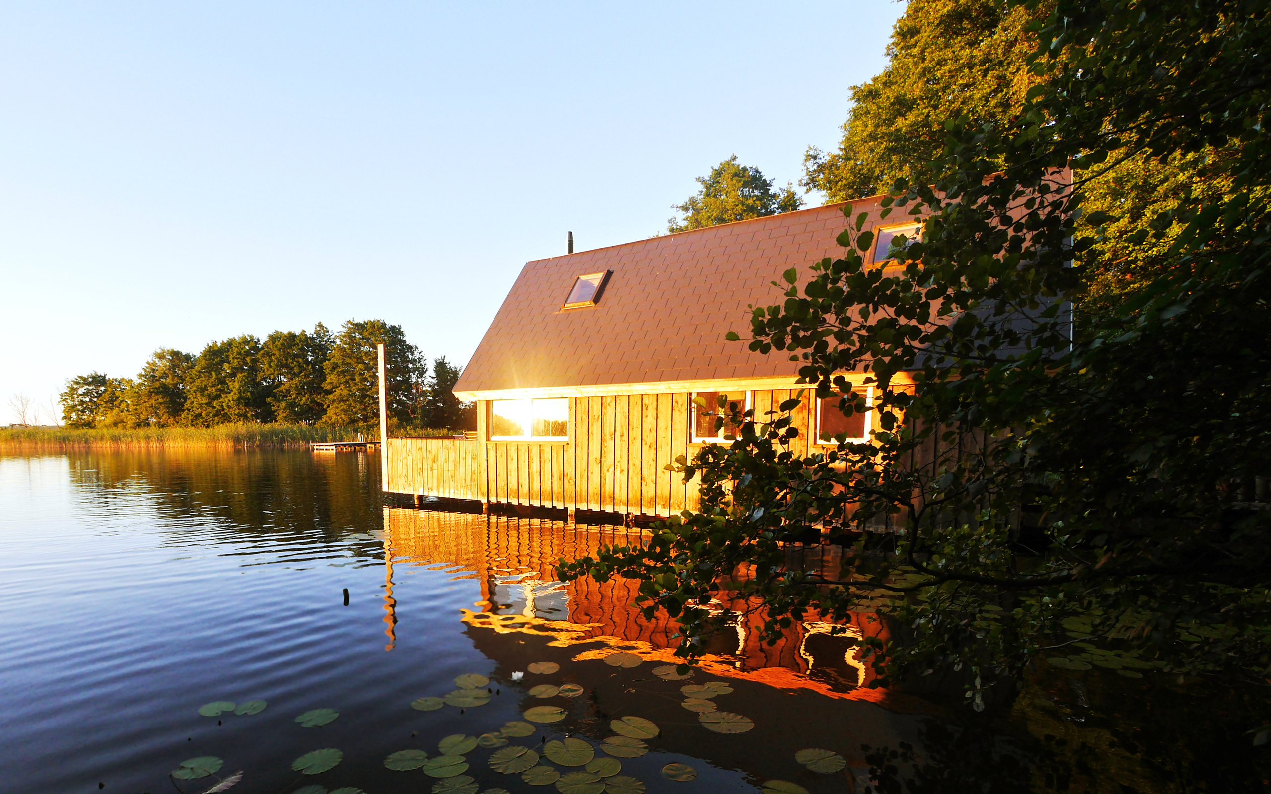 the sun reflects off a home on a lake