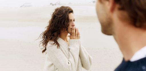Woman outside looking into the distance as man in profile looks at her