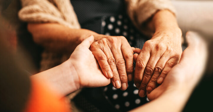 Young relative holding the hands of an elderly woman