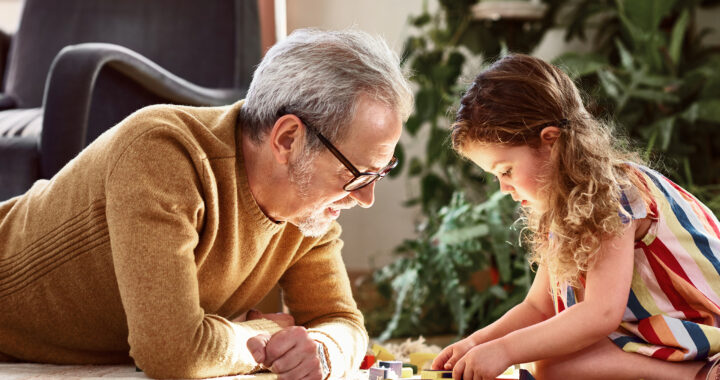 A man and a young girl work on a puzzle together